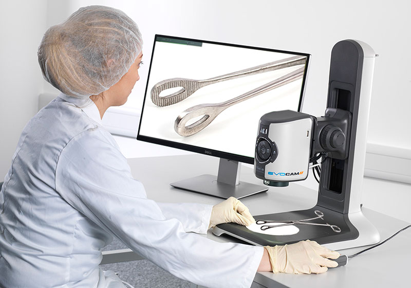 Woman conducting surgical instrument inspection with digital microscope