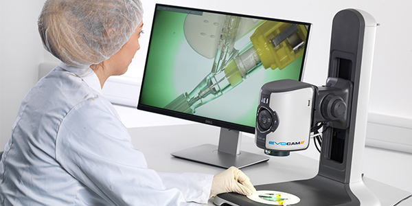 operator in white coat and hair net using EVO Cam II digital microscope