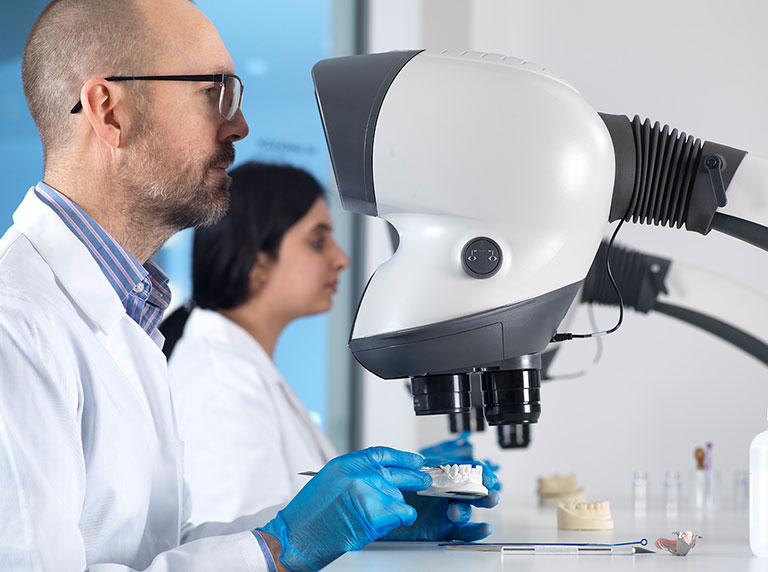Technician using Mantis Elite stereo microscope for dental application