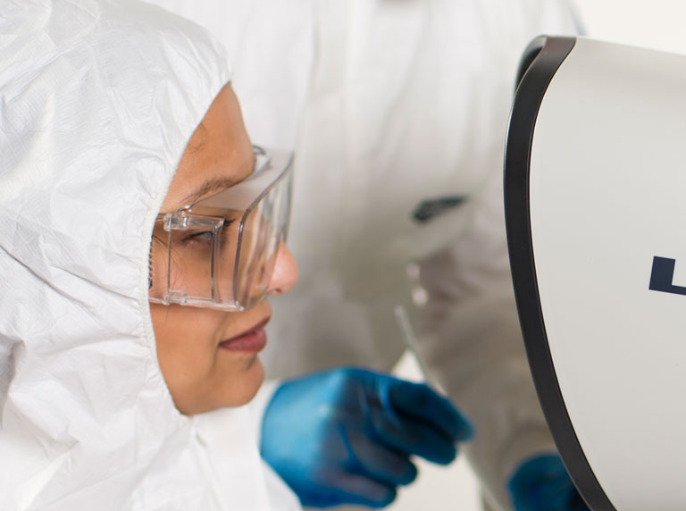 Lynx EVO microscope woman wearing glasses and full PPE