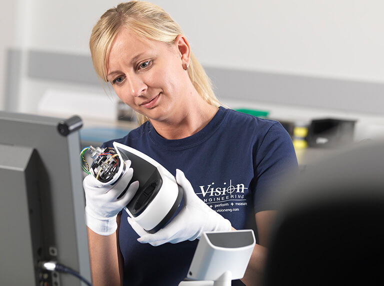 woman checking product assembly in manufacturing facility