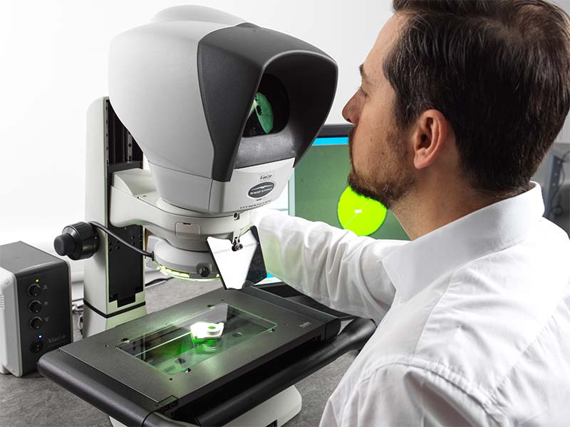 Man looking through Swift PRO toolmakers microscope inspecting a part