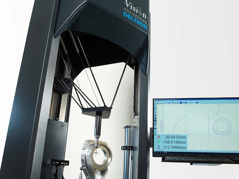 Deltron CMM measuring metal part with touch probe showing results on monitor
