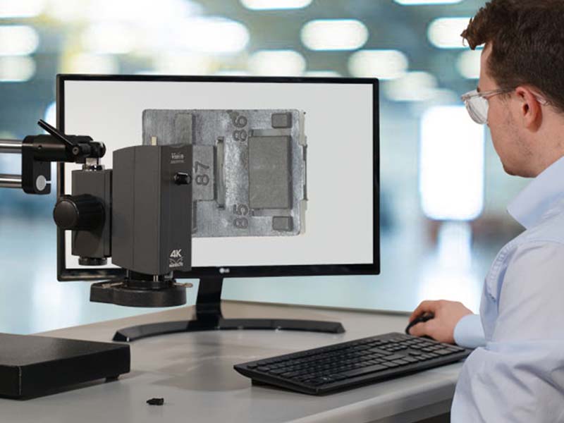 man looking at screen of component using Makrolite 4K digital microscope