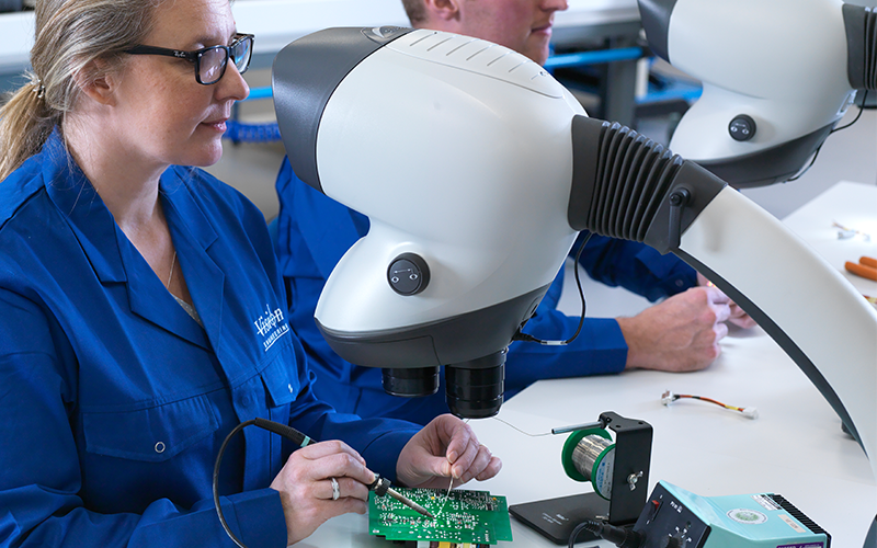 woman using Mantis microscope for soldering PCB