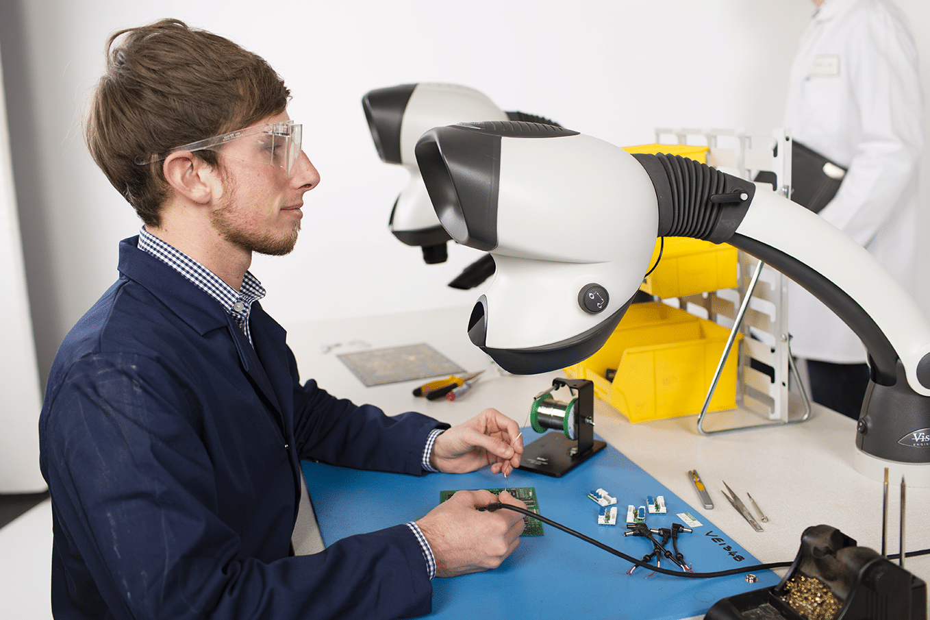 A man soldering an electronics part using Mantis microscope