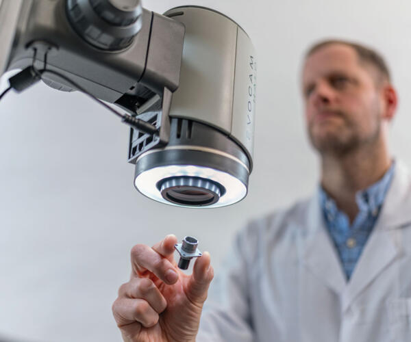 Man inspecting a metal component with HALO digital microscope
