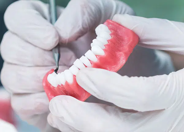 Teeth moulding being worked with a dental tool