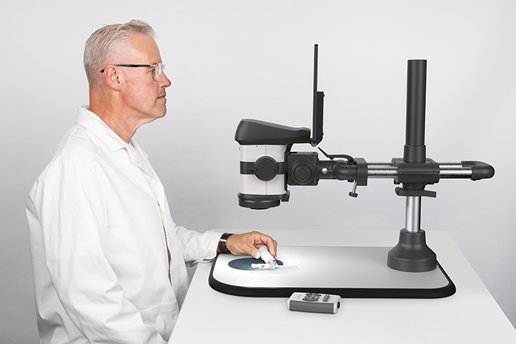 Hombre observando un dispositivo médico con el microscopio estereoscópico digital ProteQ VISO
