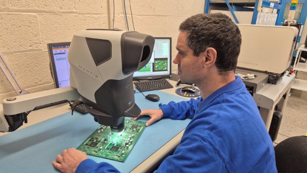 A technician using Mantis PIXO to inspect an electronics PCB